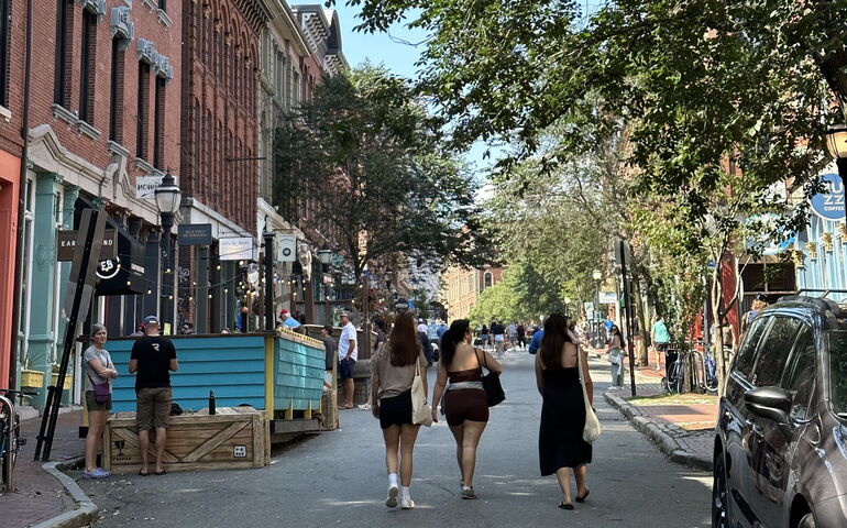 A street in downtown Portland shows people strolling around.