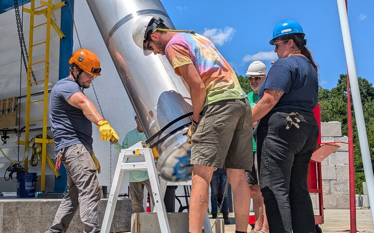 People at bluShift install a tank.