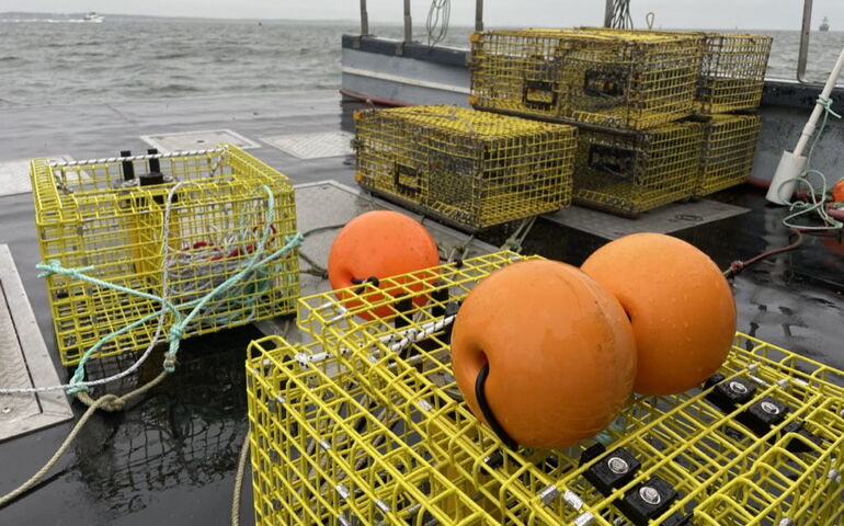 Lobster traps are on the decik of a boat.