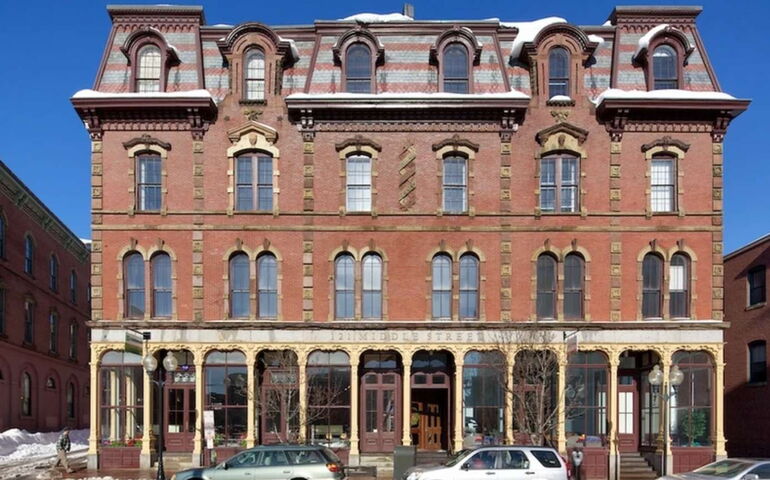 A brick building exterior has old design features.