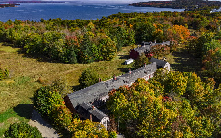 An aerial view of land, water and buildings