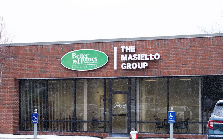 A brick building with big windows and signage.