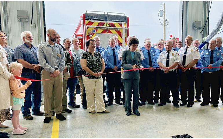 A group of people gather around a ribbon.