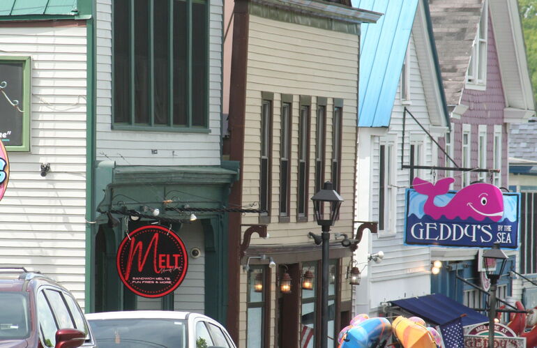 Stores along a street with signs on the fronts.