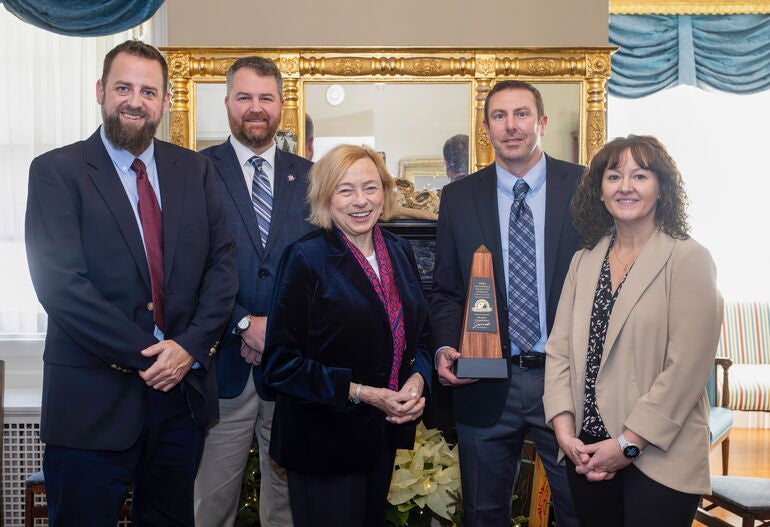 Five people pose with an award.