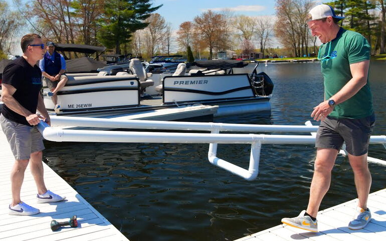 Docked owners Steven Gendron and Josh Cecot lifting the Docked product into the lake.