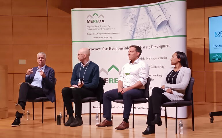 Four panelists seated on a stage