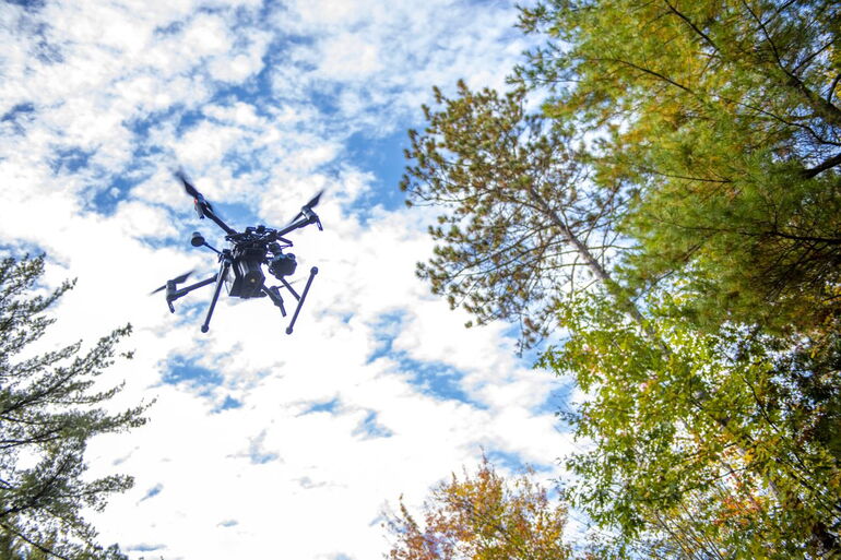 Drone above a forest in UMaine mapping activities
